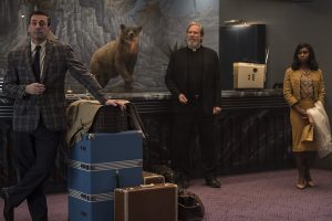 Three people checking into the El Royale Hotel