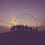 Graduates throwing their grad caps to look like a rising sun