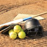 Softball balls, helmet, and bat at home plate