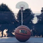 NBA basketball in front of a basketball hoop outside