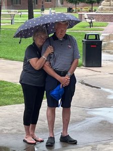 A couple attending the Prayer Walk huddled beneath an umbrella