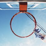 An outdoor basketball hoop pictured from below