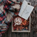 Leaves with a scarf, journal, and hot cocoa