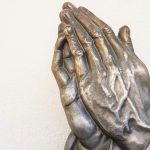 The hands of a statue held together in a prayer motion