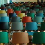 Many multicolored chairs in an empty auditorium