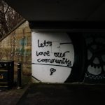 Painting on a wall that reads "Let's love our community"