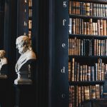 The space between shelves in a library, lined with marble busts